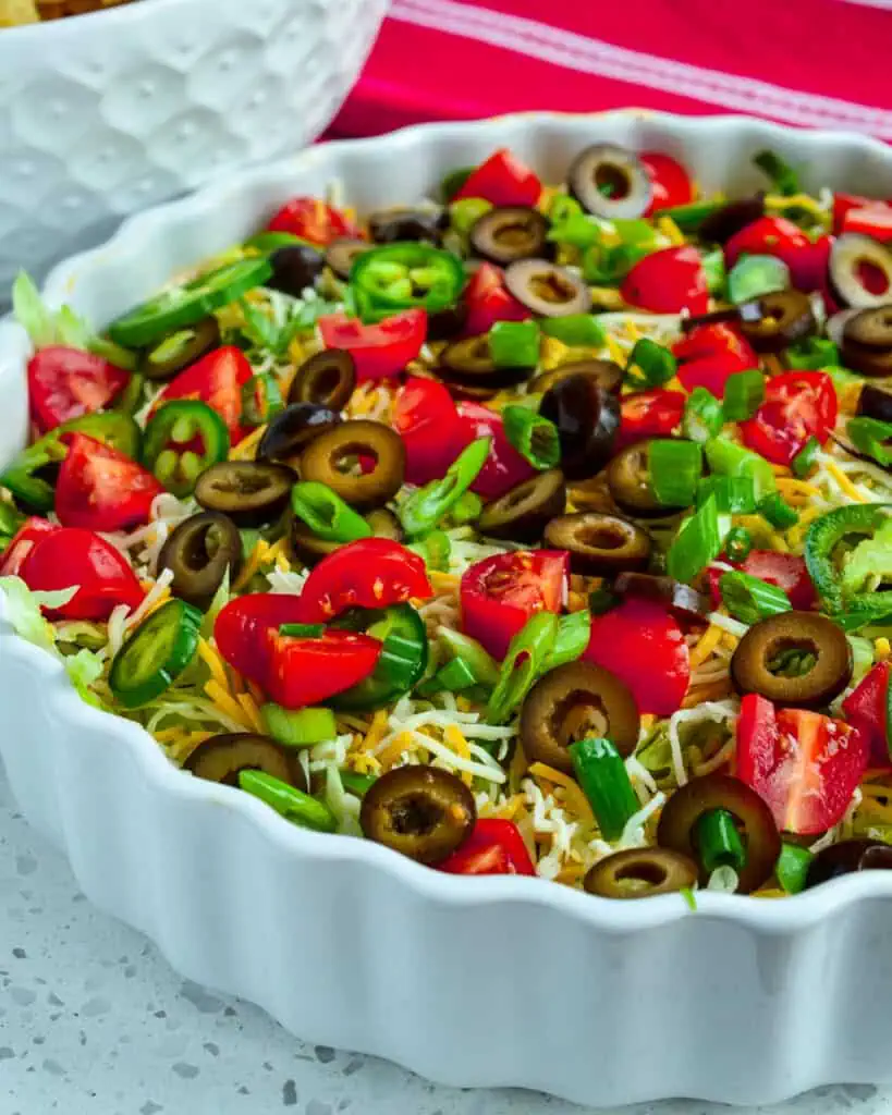 This delicious and easy Taco Dip with a sour cream and cream cheese base comes together in less than ten minutes. 