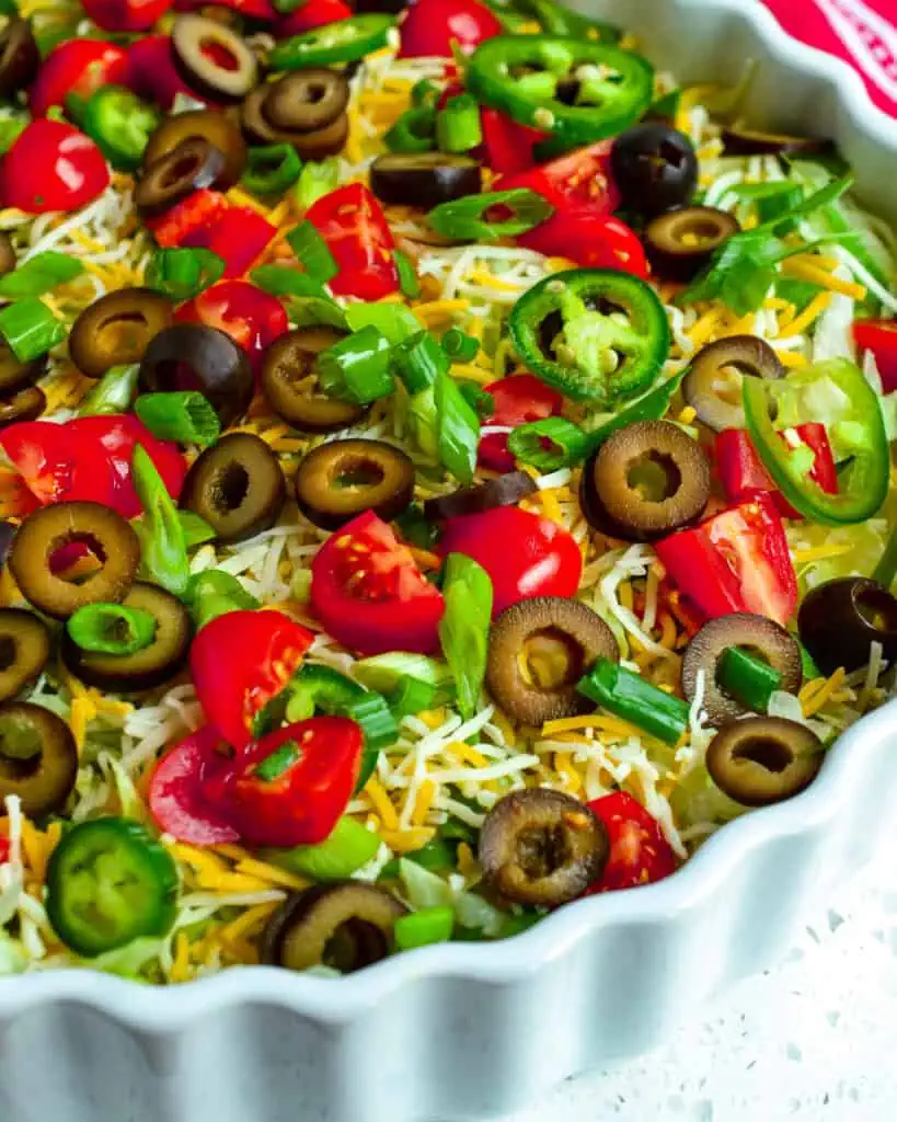 This scrumptious Taco Dip Recipe is made in less than 10 minutes complete with a beautiful array of toppings