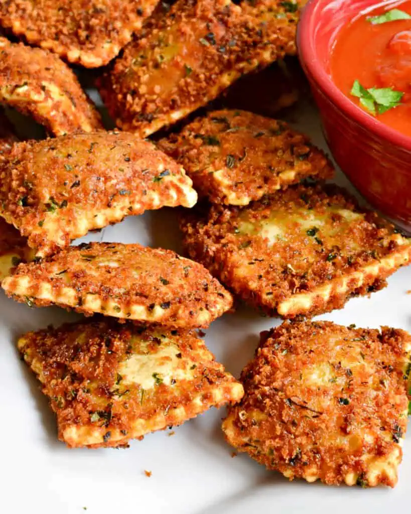 Toasted Ravioli are seasoned, breaded ravioli that are deeply fried and served with marinara and a sprinkle of Parmesan cheese.