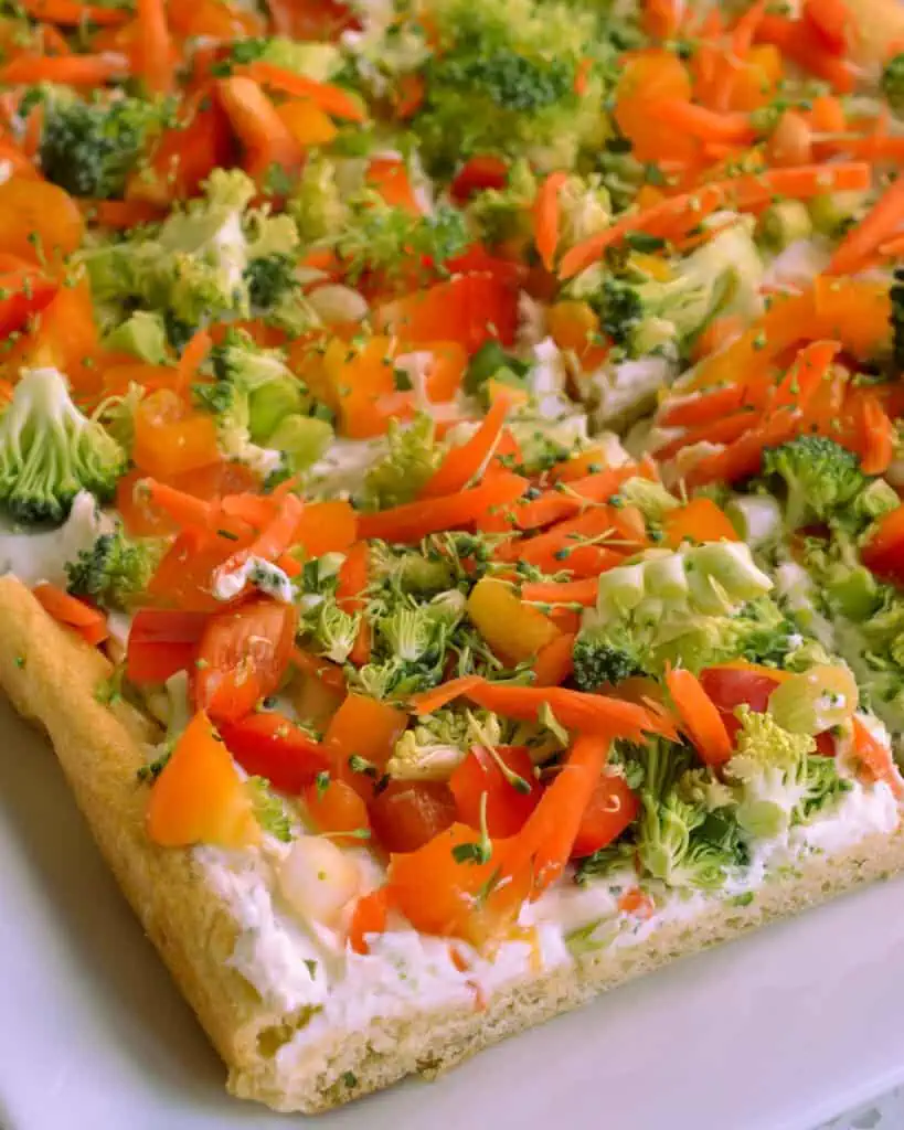 Crescent roll pizza topped with ranch cream cheese and vegetables. 