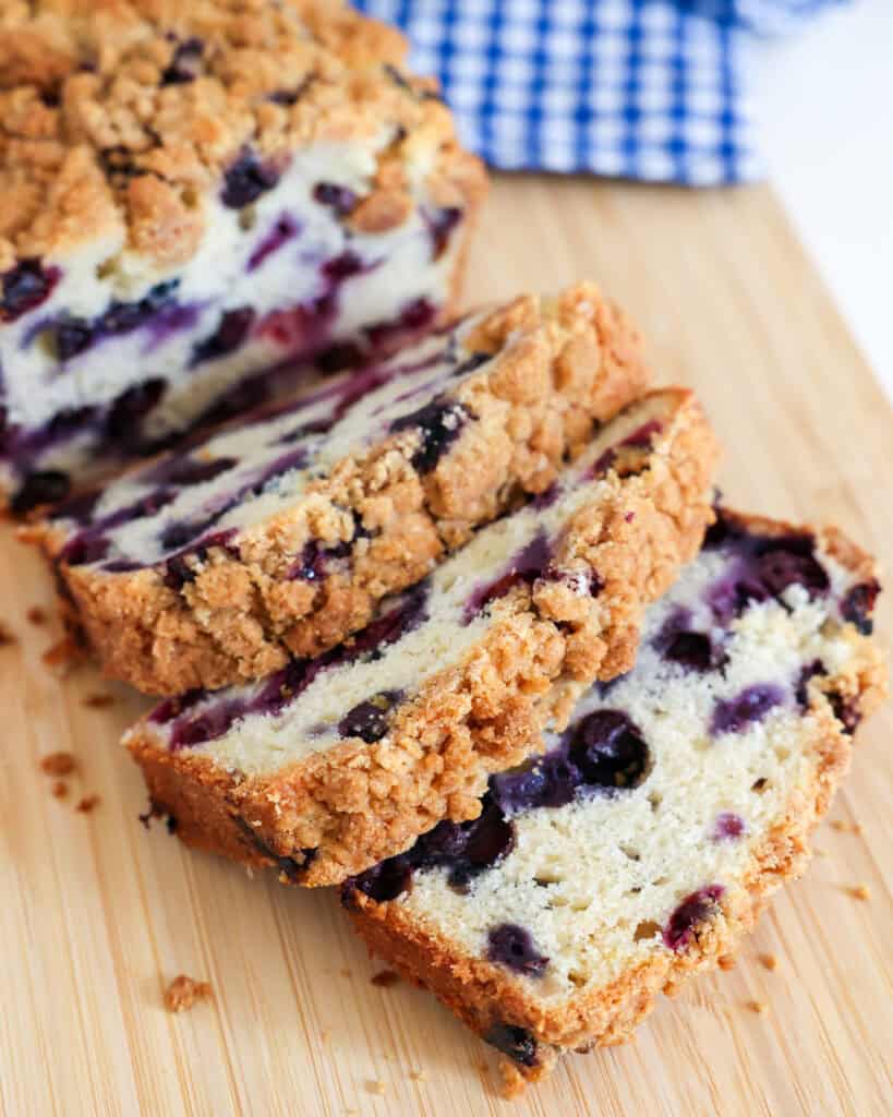 Slices of homemade blueberry bread on a cutting board. 