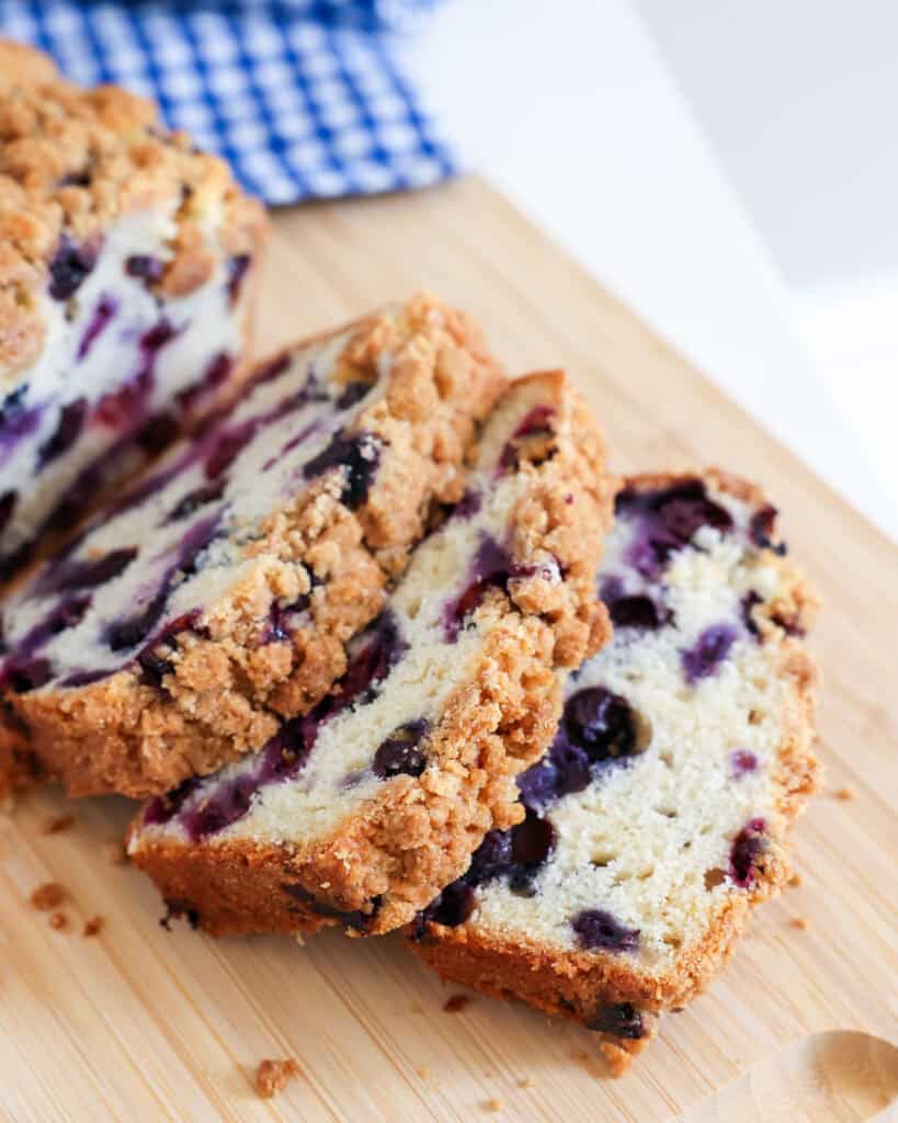 Sliced blueberry bread on a cutting board.