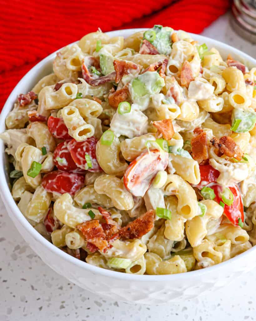 Chicken Pasta Salad Recipe combines elbow macaroni and cooked rotisserie chicken with the flavors of crispy smoked crumbled bacon, grape tomatoes, diced avocado, and green onions, in a creamy mayonnaise dressing with a touch of honey, garlic, and mustard.