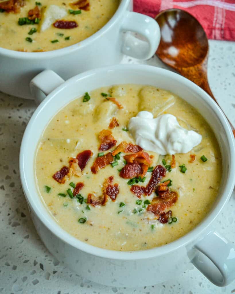 An overhead views of a bowl full of loaded potato soup garnished with bacon and chives. 