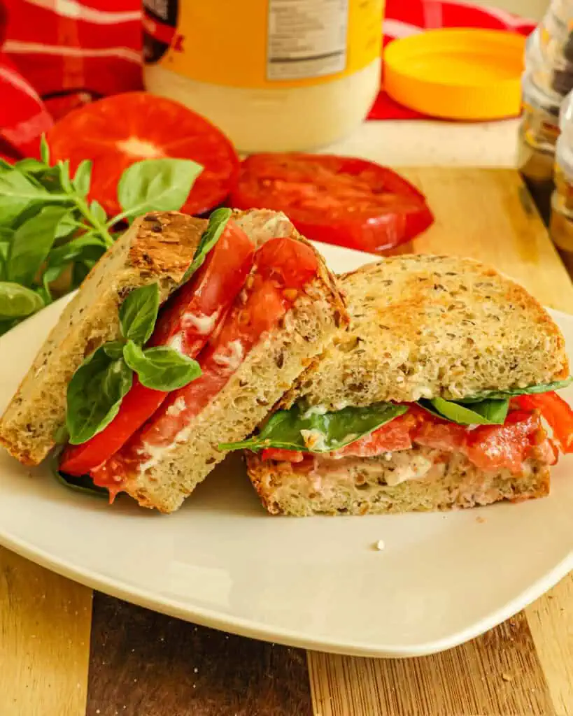 A tomato sandwich on artisan bnread with mayo. 