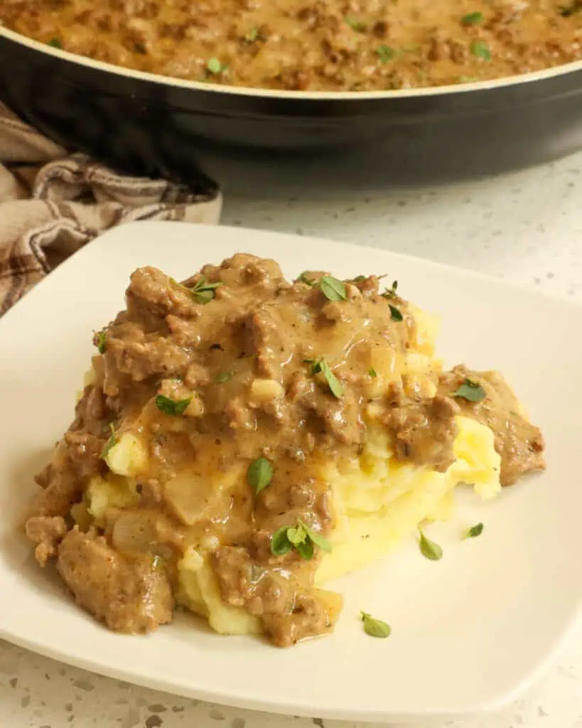 A plate full of hamburger gravy over mashed potatoes. 