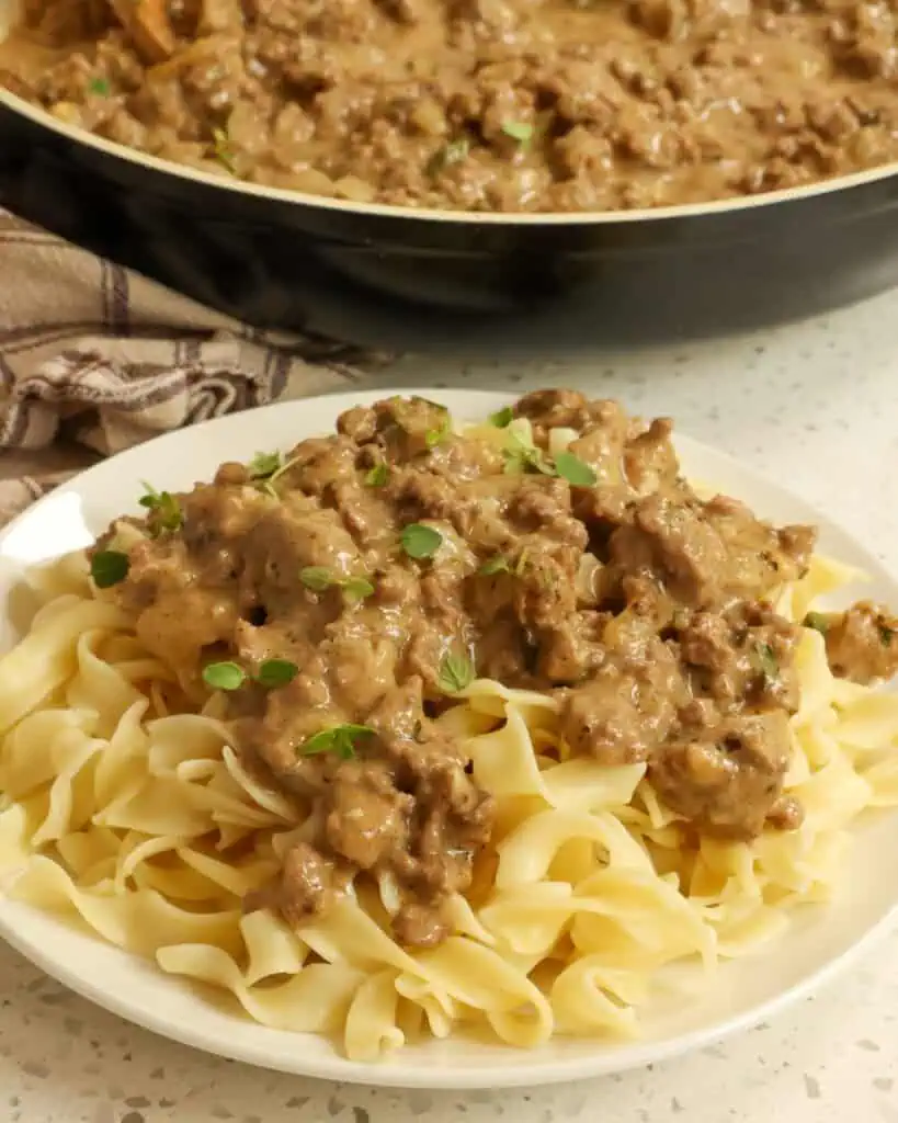 A plate and a skillet full of hamburger gravy. 