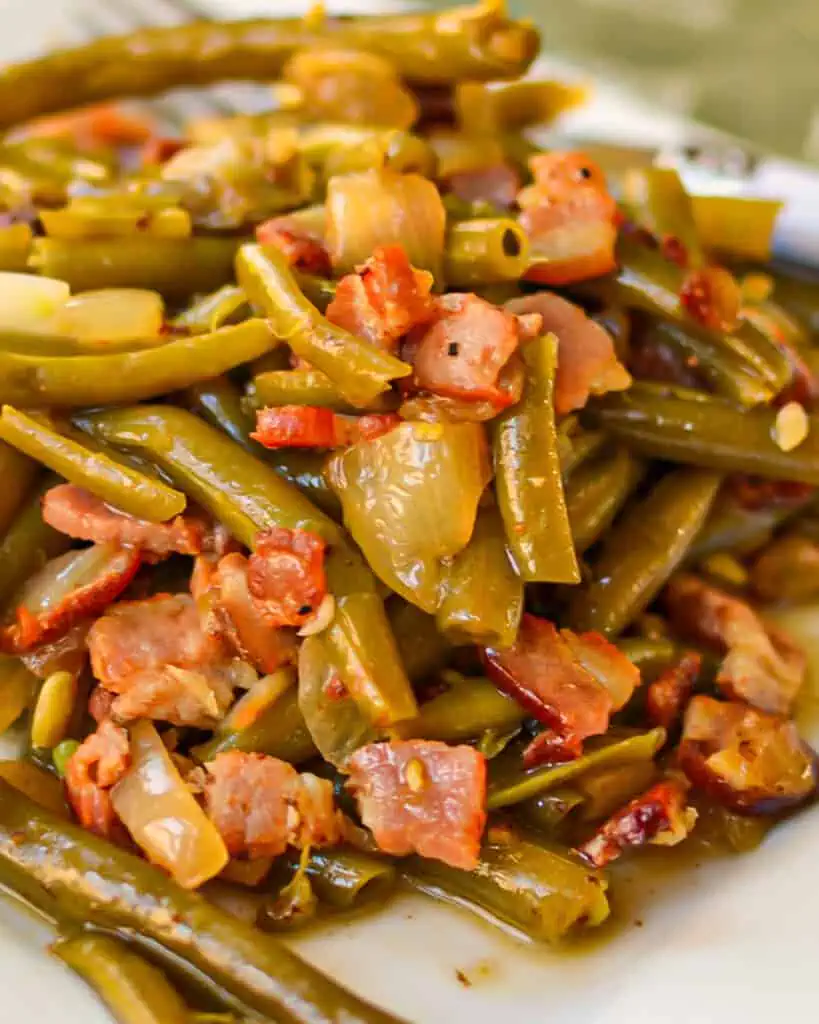 Southern green beans on a plate with a serving fork. 