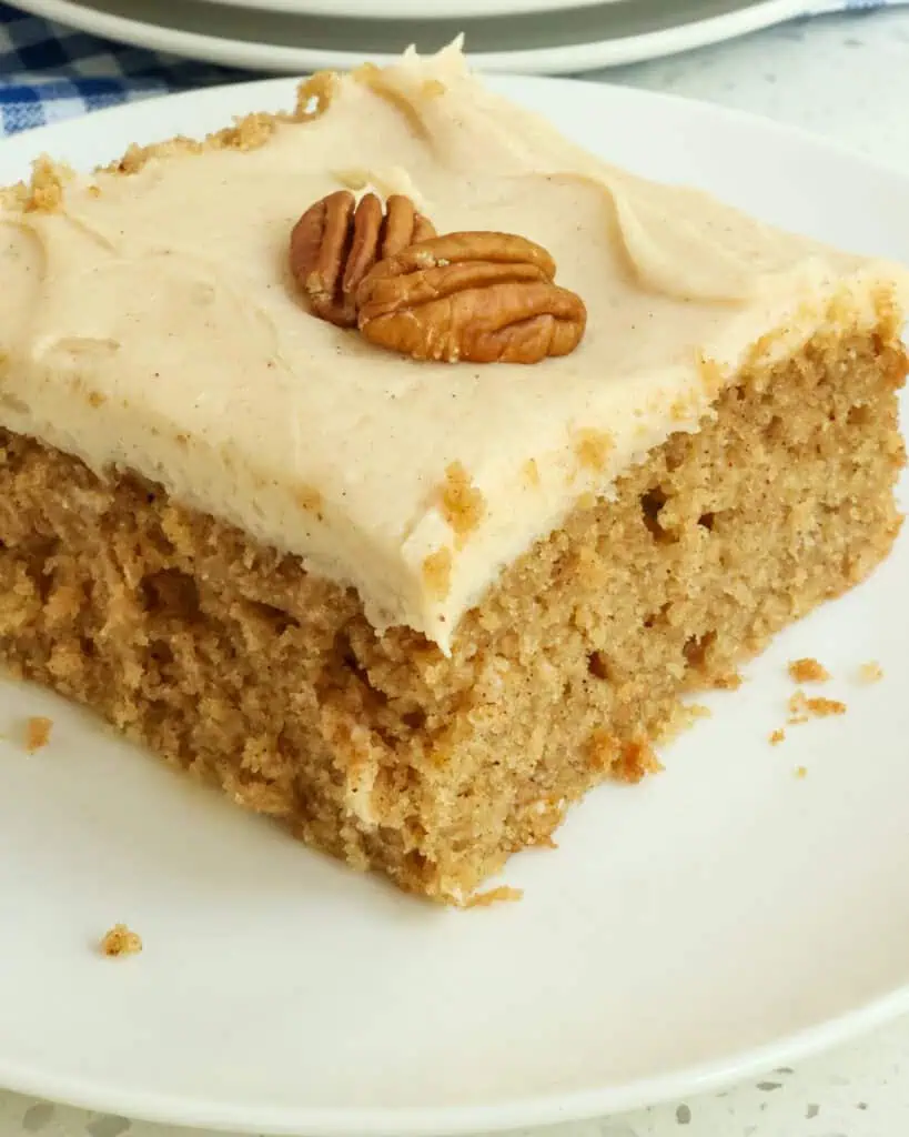 A close up view of a piece of applesauce cake with cream cream frosting. 