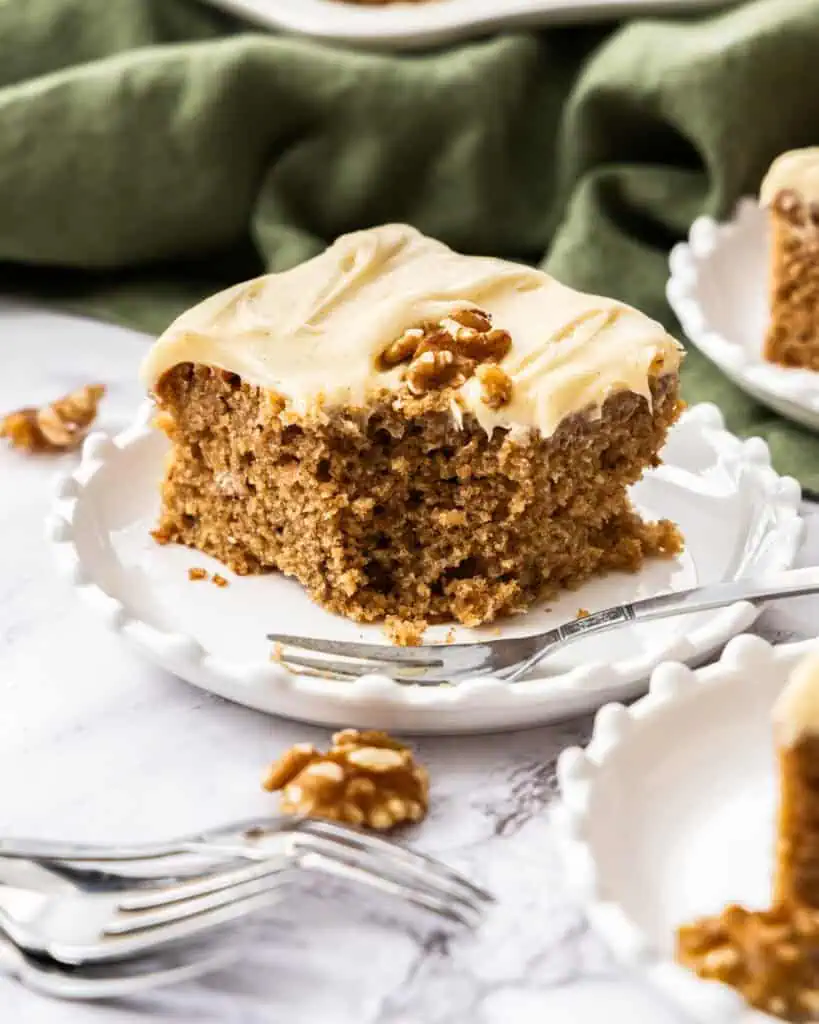 A close up view of a piece of applesauce cake with cream cream frosting. 