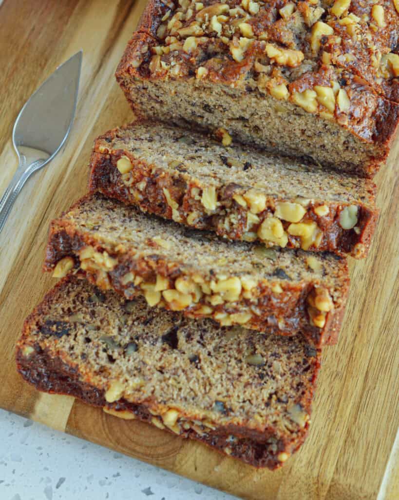 Three slices of banana bread on a cutting board. 