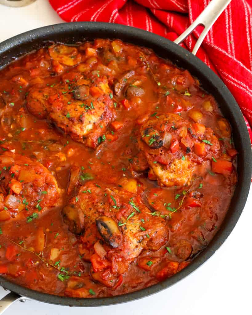 Chicken Cacciatore Recipe Chicken cacciatore sprinkled with fresh herbs in a large skillet.