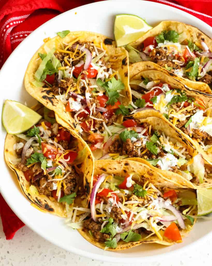 Ground beef tacos with all the fixings in blackened corn tortillas. 