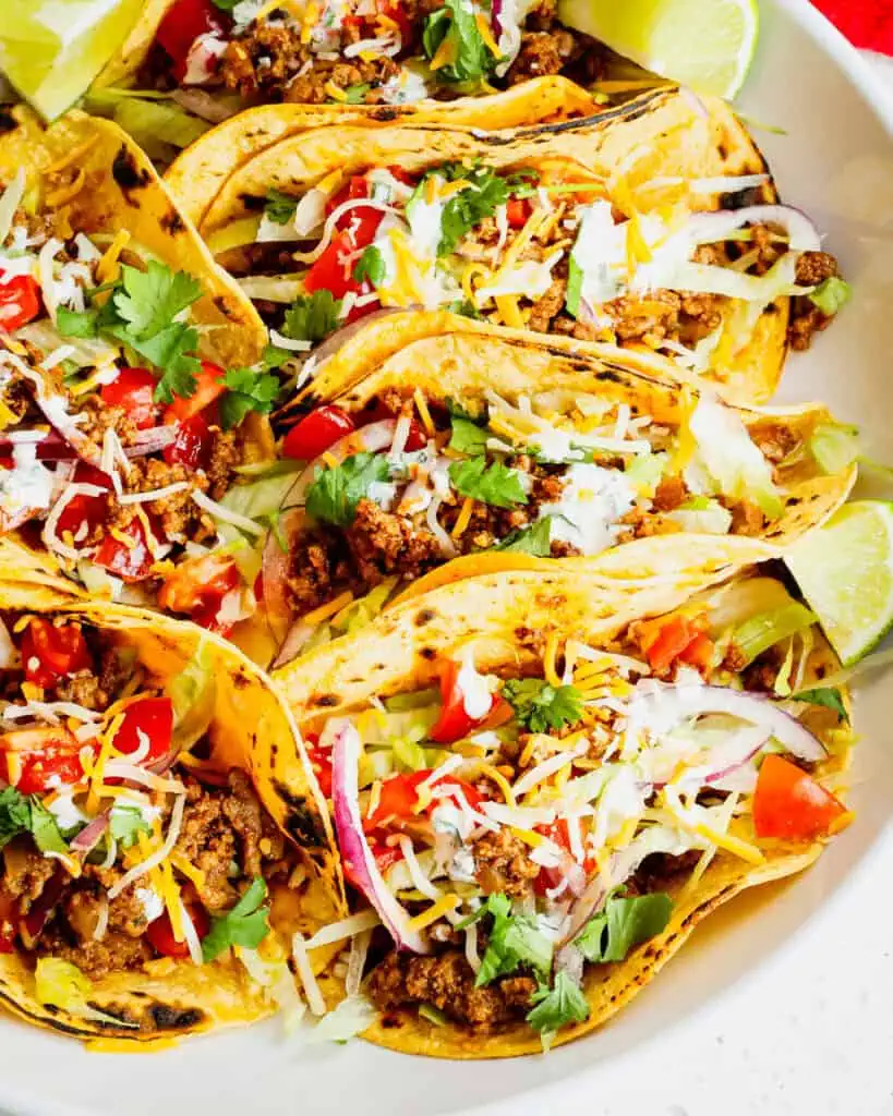 Ground beef tacos in corn tortillas in a bowl.