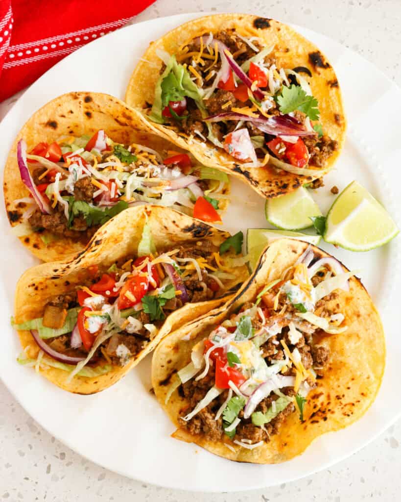 Ground beef tacos with all the fixings in blackened corn tortillas. 