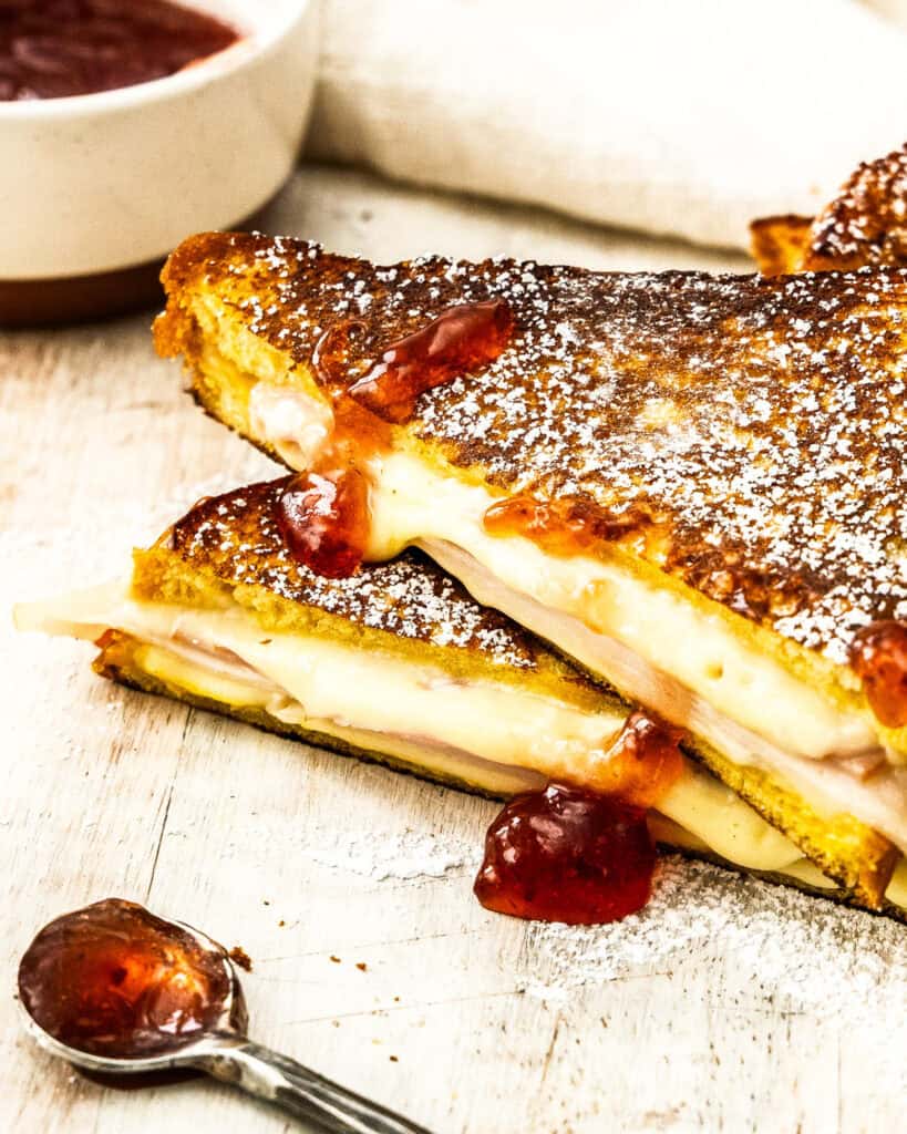 A close up view of a monte cristo sandwich with raspberry jham.