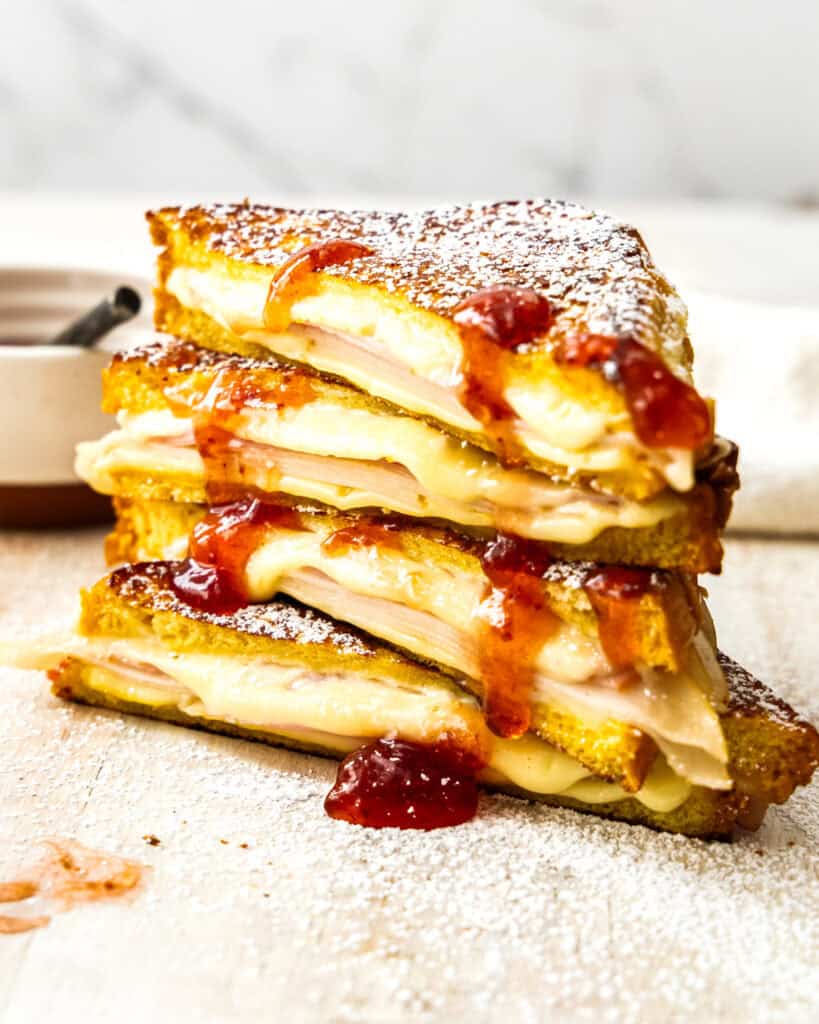 A close up view of two stacked monte cristo sandwiches with raspberry jam.