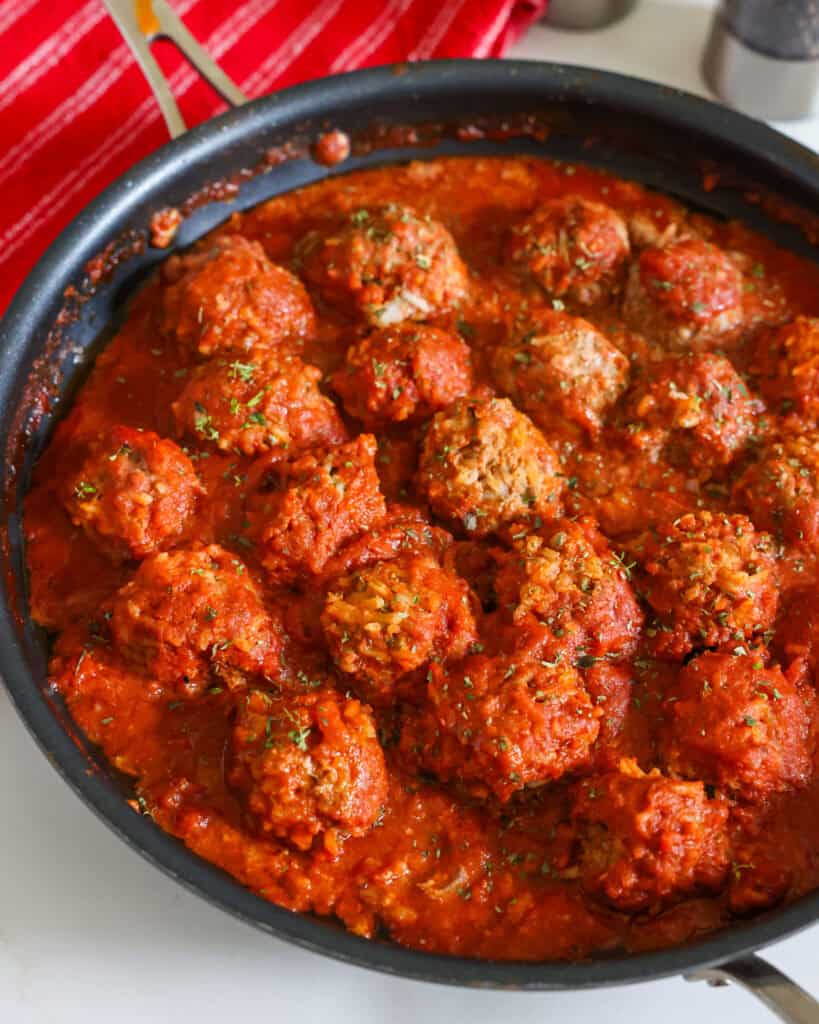 Porcupine meatballs in tomato sauce in a skillet.