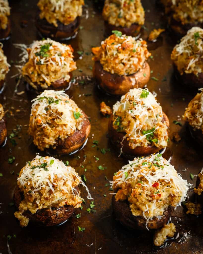 Sausage stuffed mushrooms on a baking sheet. 