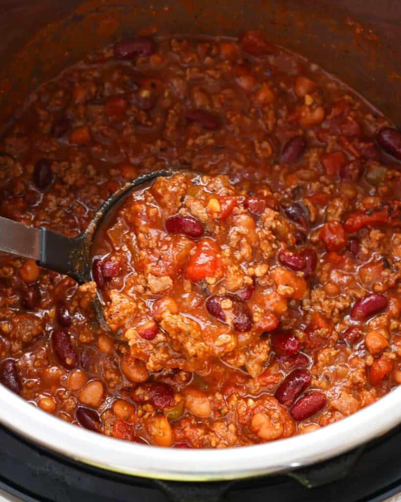 An instant pot and a ladle full of chili.