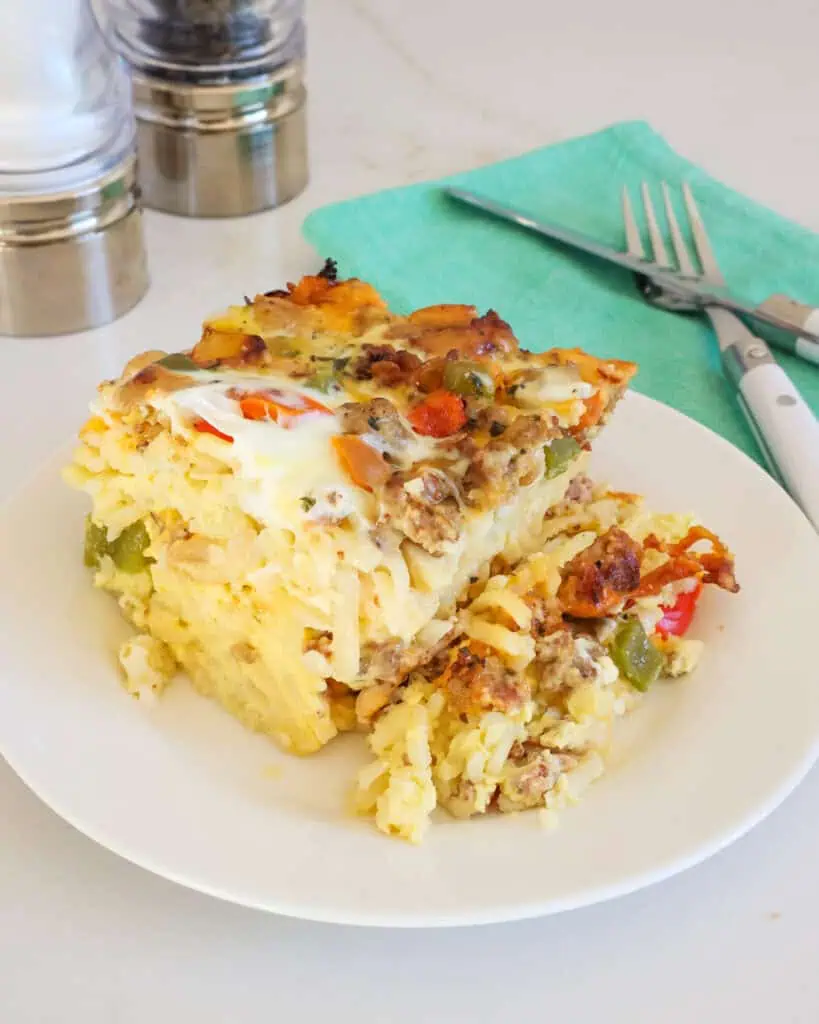 A piece of crock pot egg casserole on a single serving plate with salt and pepper shakers in the background. 
