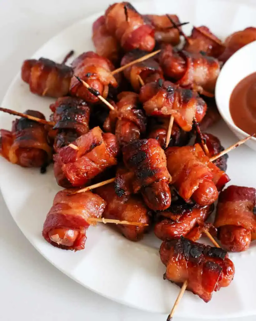 Bacon Wrapped Little Smokies A plate full of smokies wrapped in bacon and basted with brown sugar.