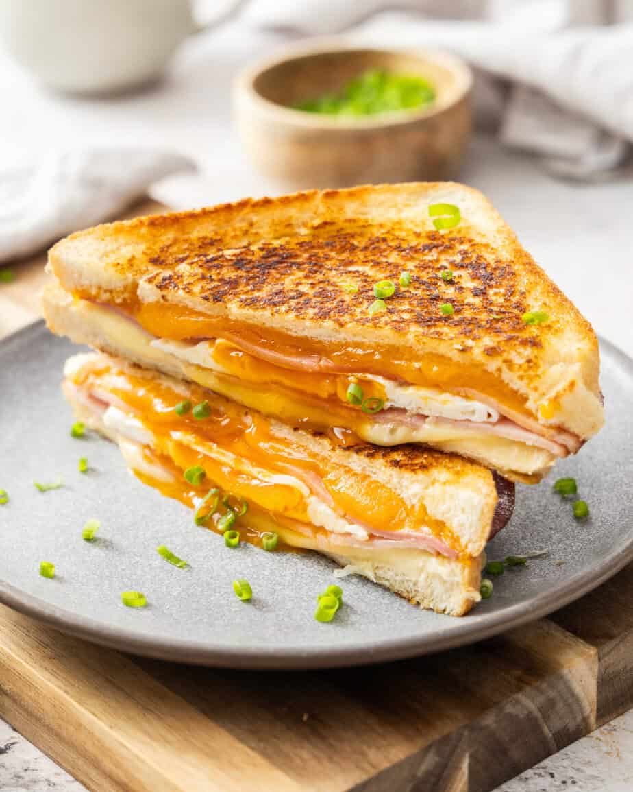 A stacked egg sandwich on a single serving gray plate.
