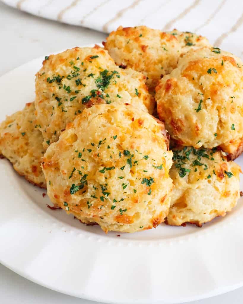 Homemade cheddar bay biscuits on a serving plate.