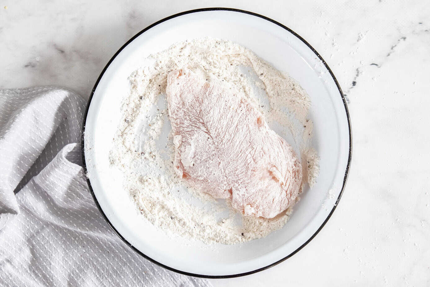 Some of the steps for making chicken florentine. Dredge the chicken cutlets in the flour mixture.