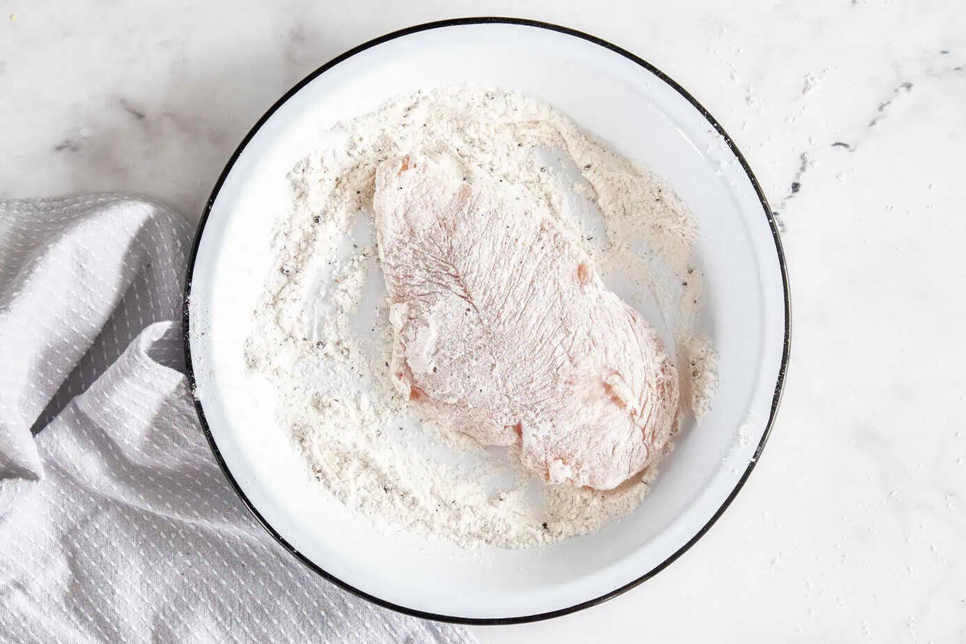 Some of the steps for making chicken florentine. Dredge the chicken cutlets in the flour mixture.