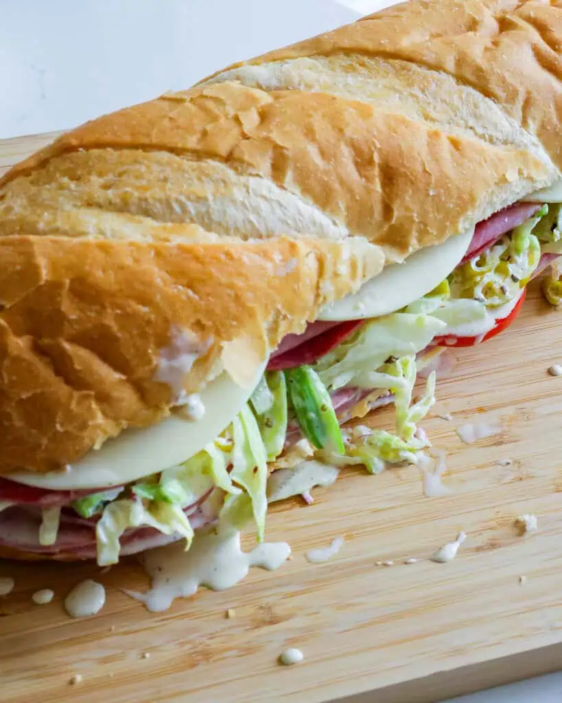 An overhead view of an Italian grinder sandwich on a cutting board. 