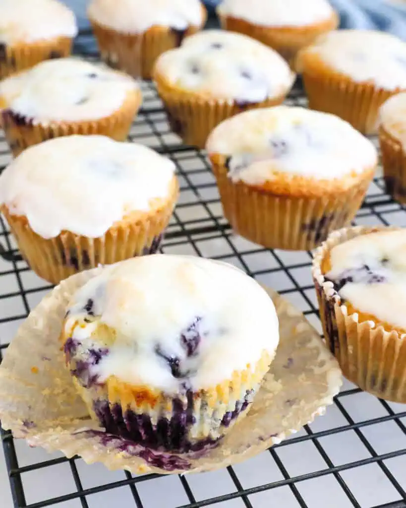 A close up view of lemon blueberry muffins on a wire cooling rack. 