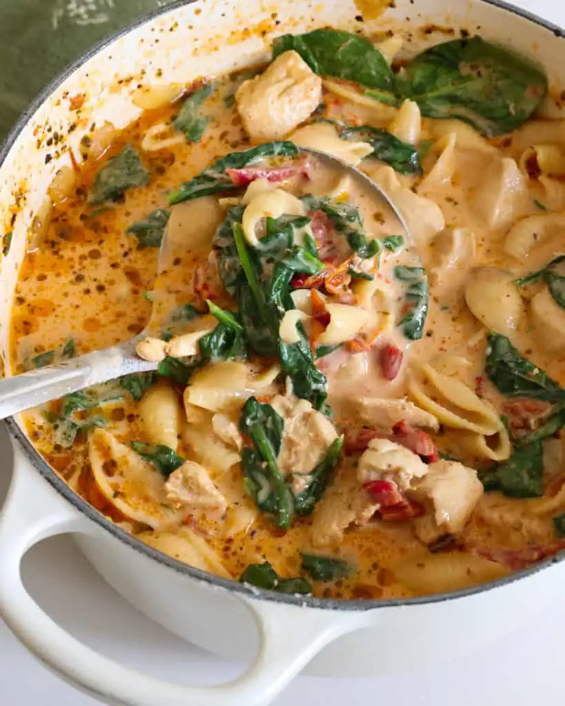 A large Dutch oven and a ladle full of Marry Me Chicken Soup. 