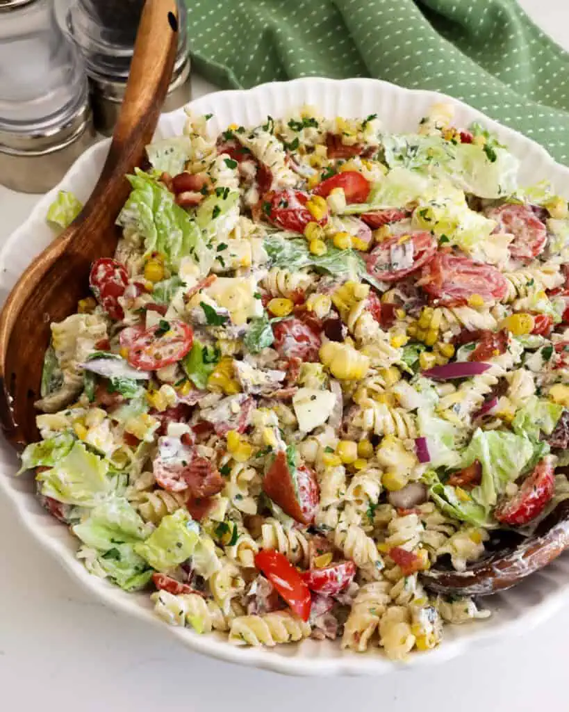 A large white serving bowl full of BLT pasta salad. 