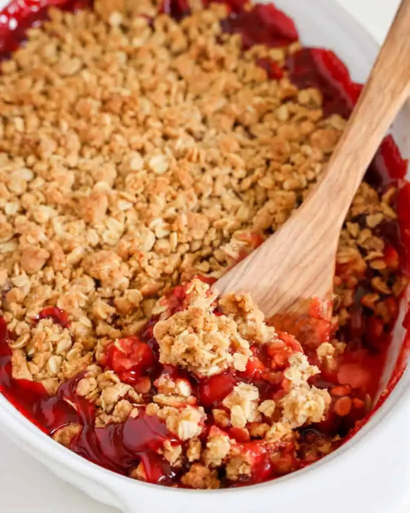 An oval baking dish full of cherry crumble. 