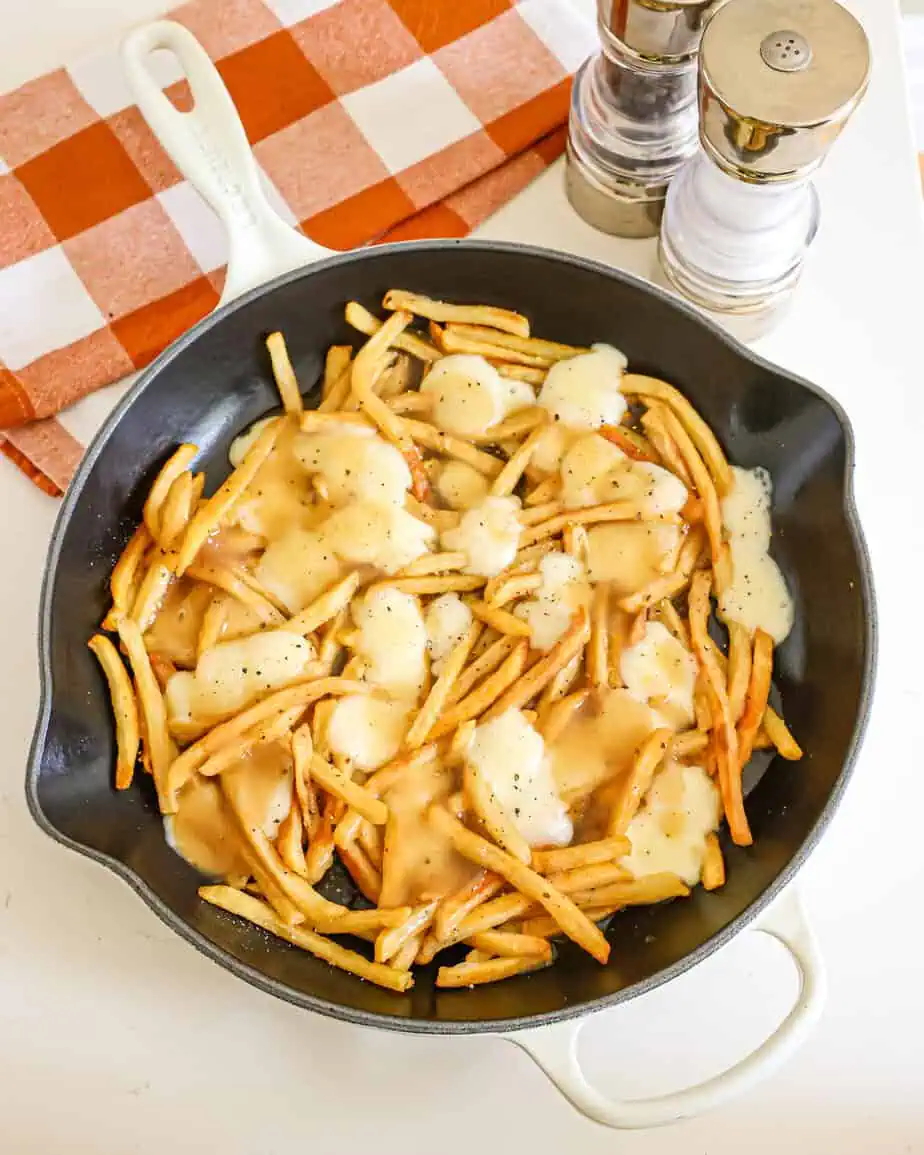 An overhead view of poutine with extra-crispy fries, melted cheese curds, and beefy gravy.
