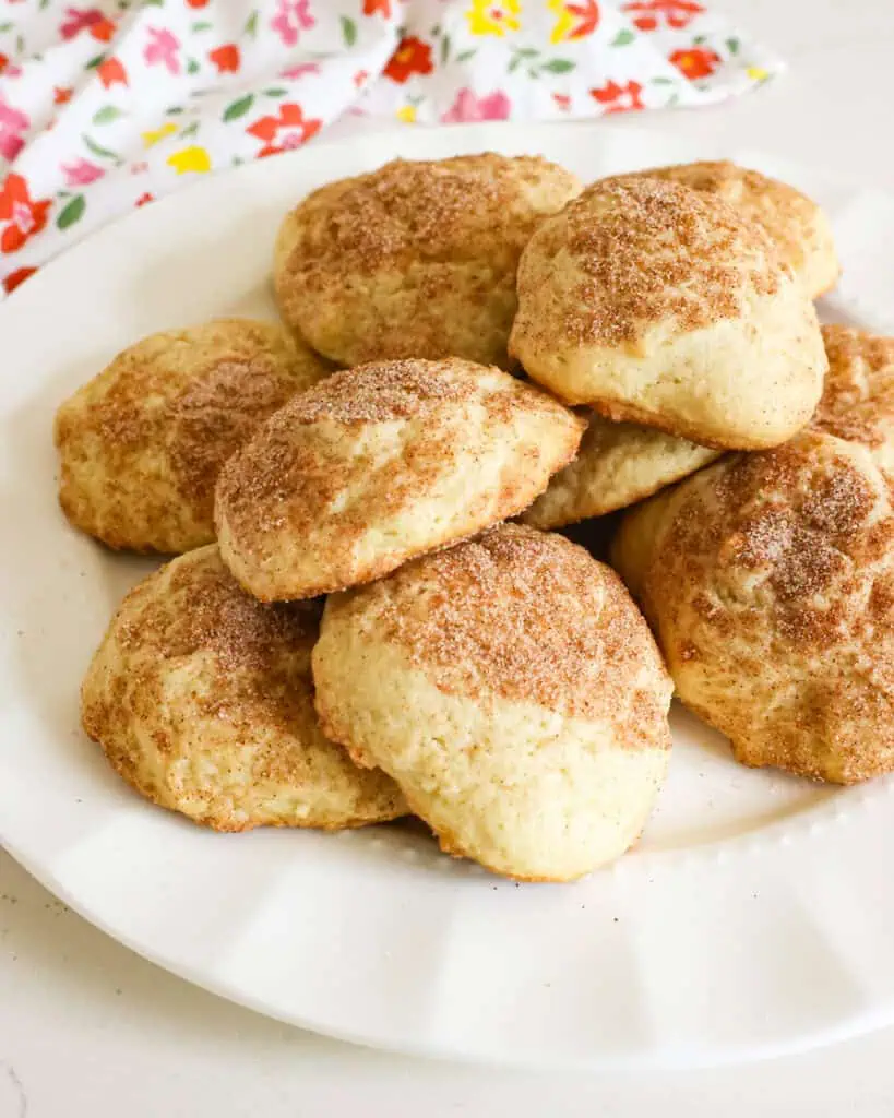 A white round serving plate full of sour cream cookies. 