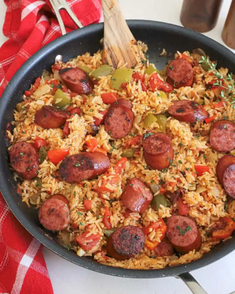 A black skillet full of Cajun style sausage and rice.