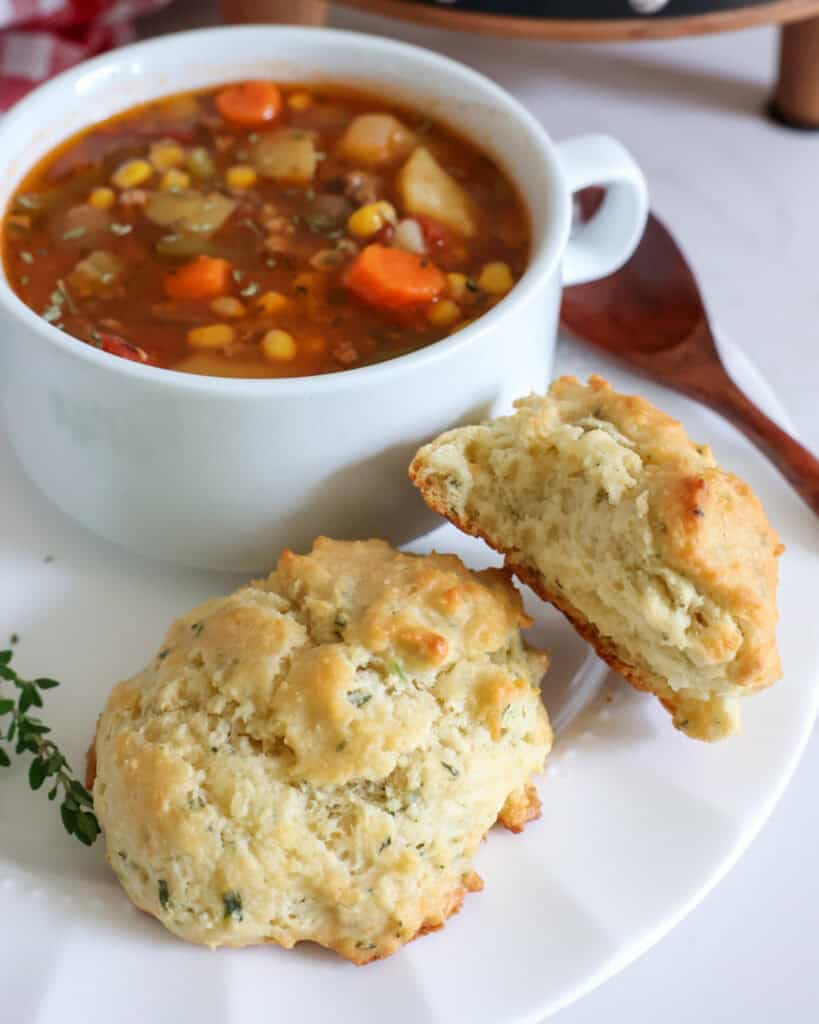 Two drop biscuits in front of a bowl of hamburger soup. 