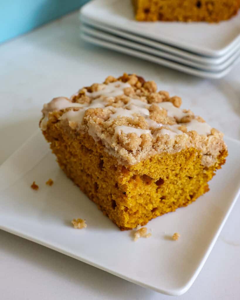 An overhead view of a small piece of pumpkin coffee cake on a single serving plate.