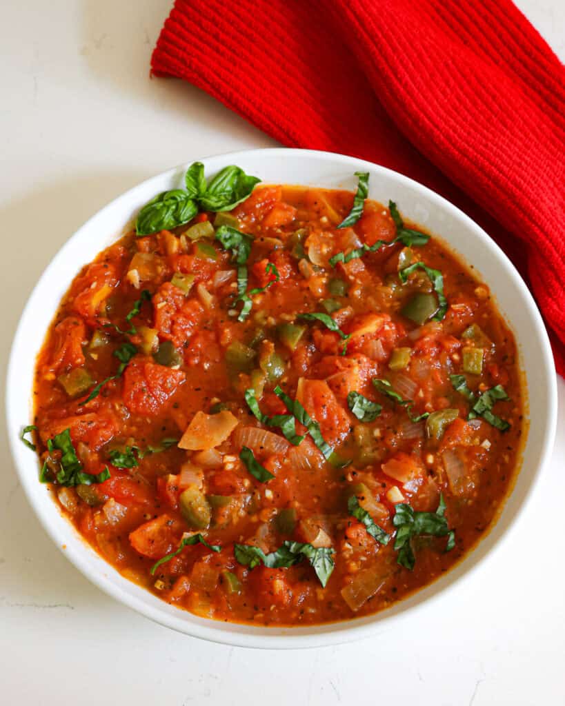 A large serving bowl full of stewed tomatoes. 