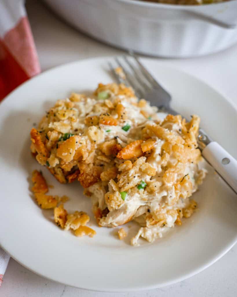 Ritz cracker chicken casserole on a single serving white plate with a fork. 