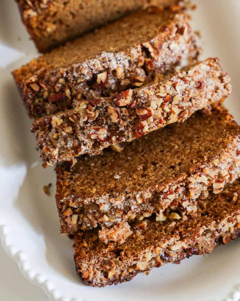 A close up view of four slices of sweet potato bread on a white serving platter.