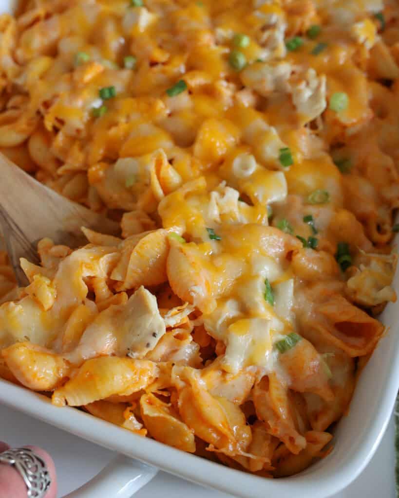 A close up view of Buffalo chicken casserole in a wooden spoon. 