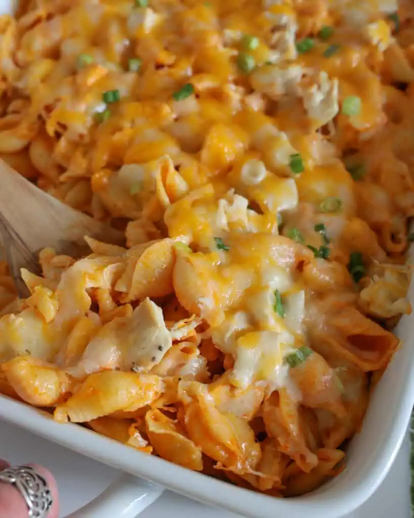 A close up view of Buffalo chicken casserole in a wooden spoon.