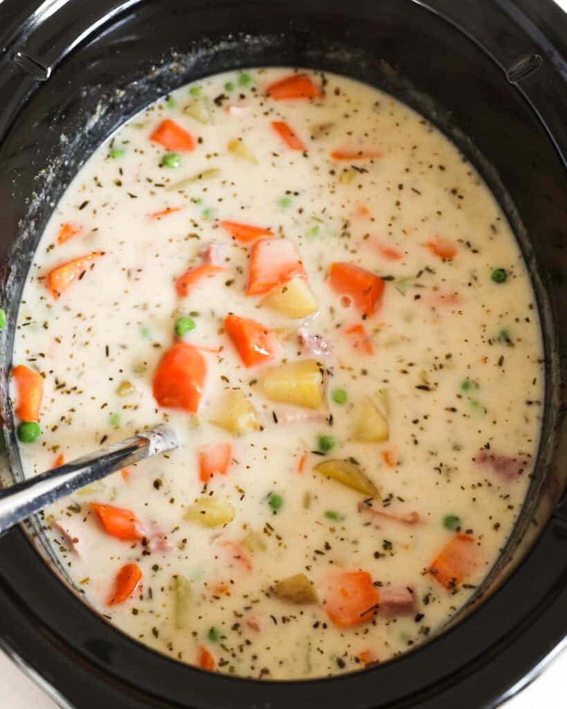A crockpot full of creamy cheesy ham and potato soup. 