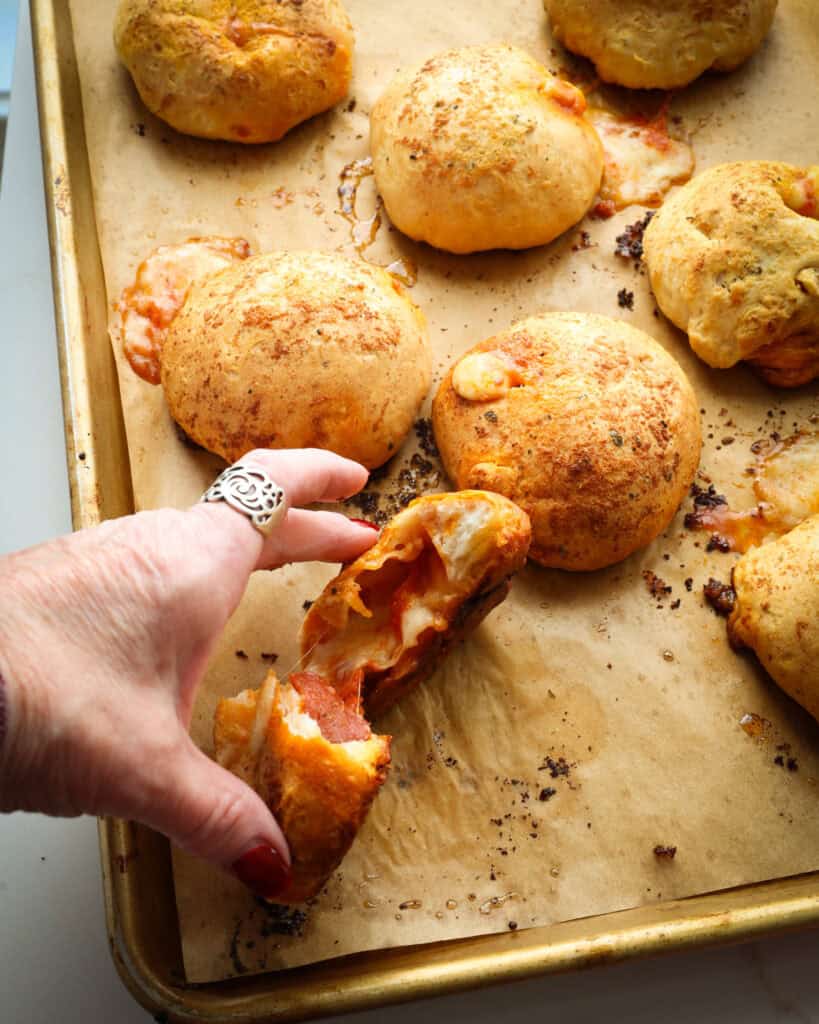 A split pizza bomb on a parchment covered baking sheet. 