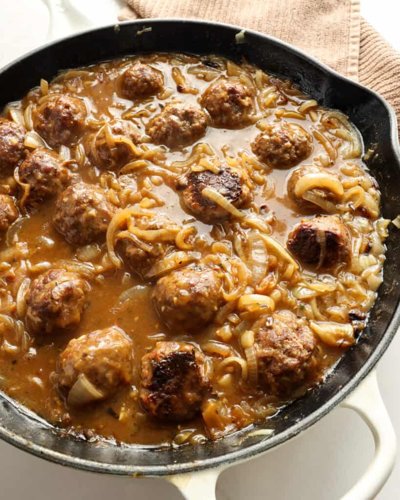 A large skillet full of French Onion meatballs. 