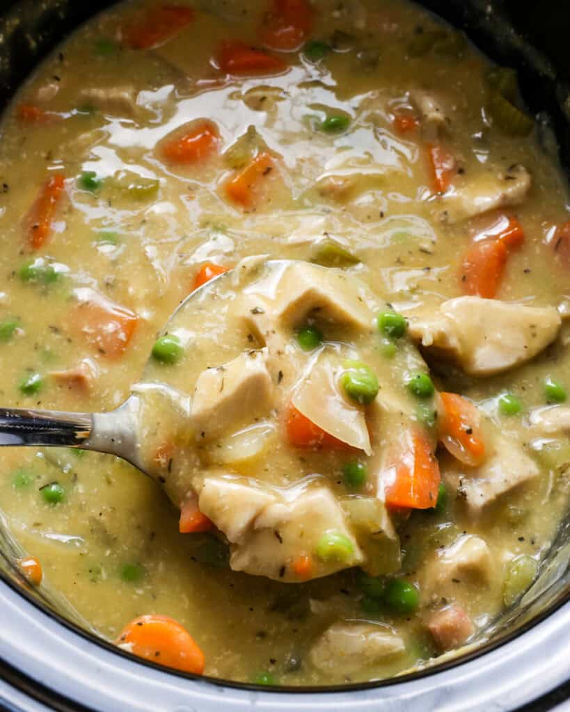 A close up view of a crockpot full of chicken pot pie. 