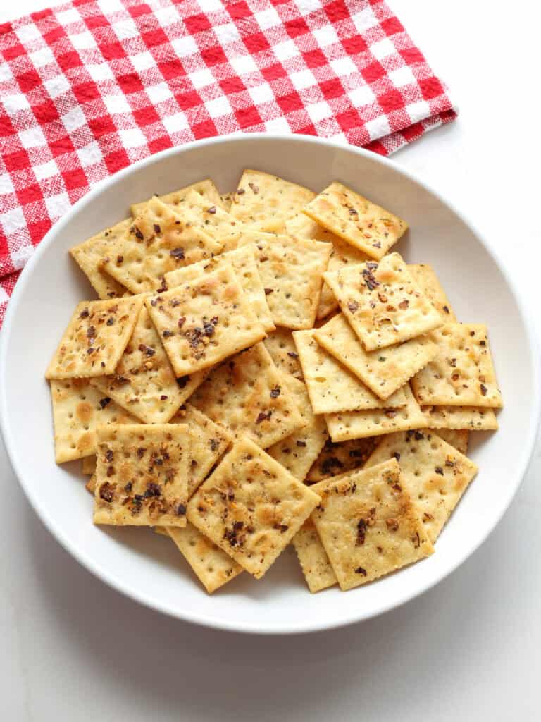 An overhead view of a white serving bowl full of Alabama Fire Crackers. 